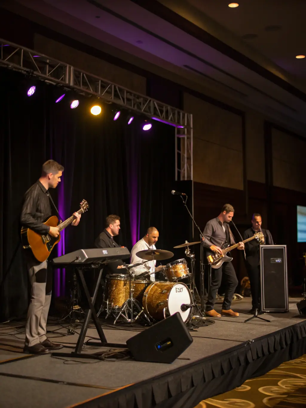 A diverse group of musicians performing on stage at a large corporate event, showcasing the variety of talent available.