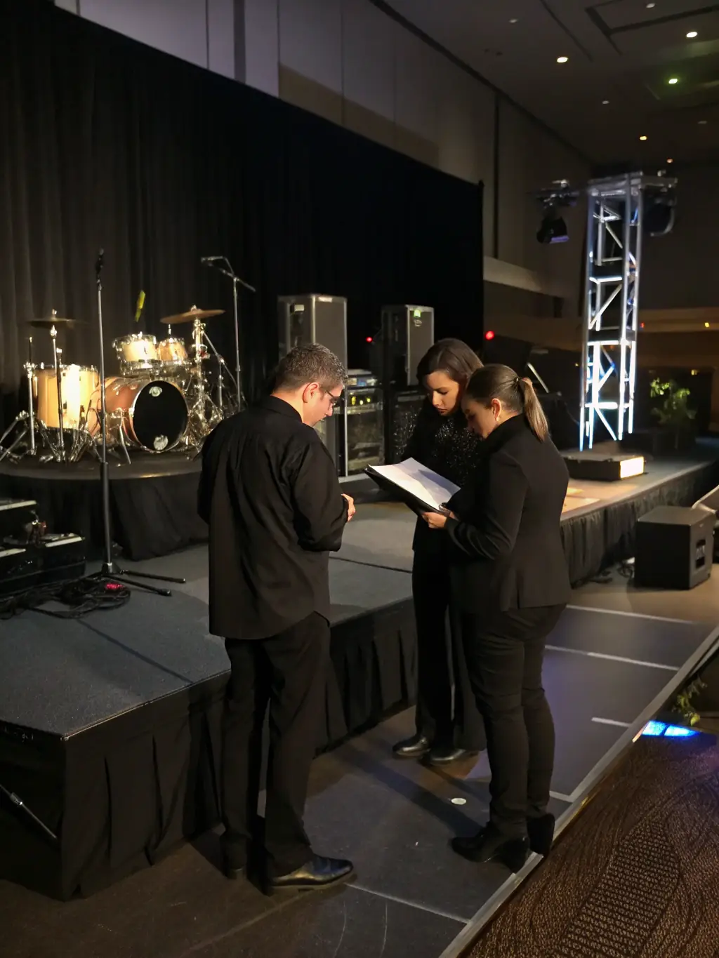 Event planners coordinating a live music performance with a well-organized stage setup, ensuring a flawless event.